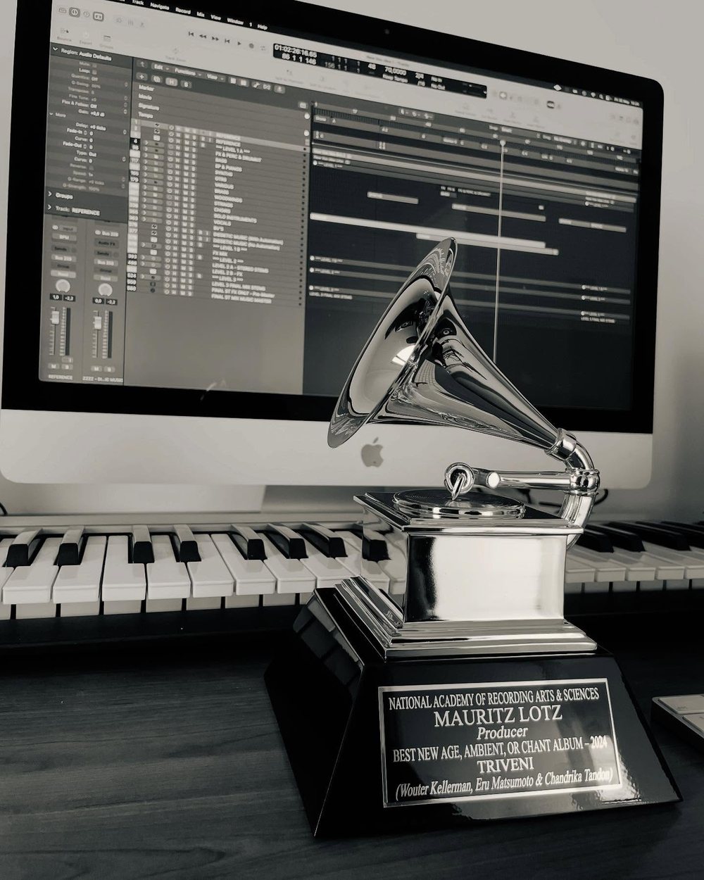 Mauritz Lotz se Grammy-toekenning op sy ateljeelessenaar, voor &rsquo;n klawerbord en &rsquo;n oop sessie op die skerm, aan hom gegraveer as produsent van Triveni, Beste New Age-, Ambient- of Chant-album, 2024